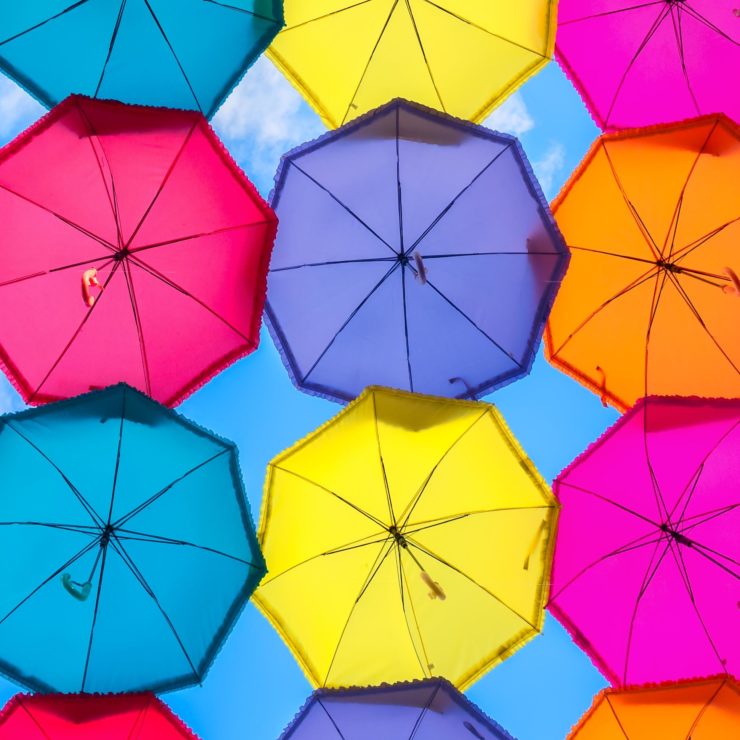 Underneath a canopy of multi-colored umbrella. This photo demonstrates how mindfulness can protect us from the negative impacts of a thought parade.
