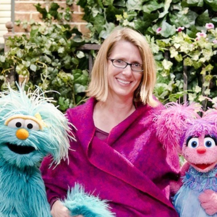 Center faculty member Julie Poehlmann-Tynan sits between two Muppets.