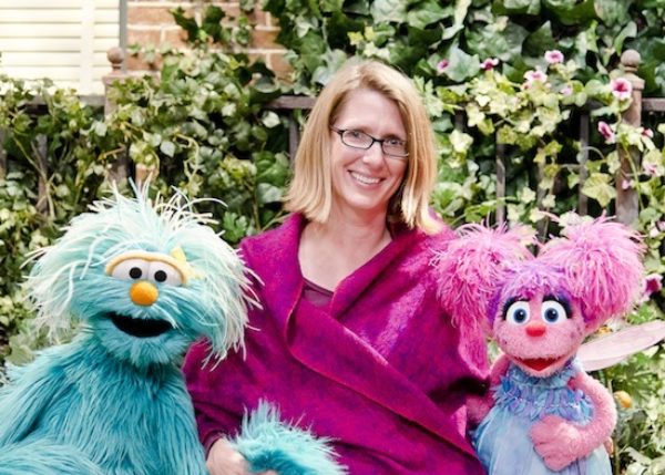 Center faculty member Julie Poehlmann-Tynan sits between two Muppets.