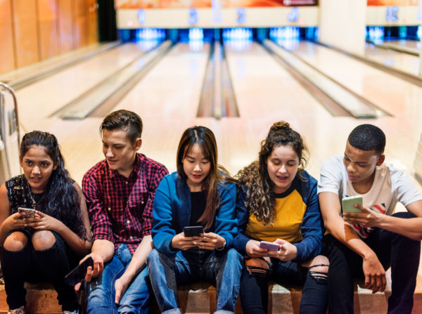 Teenagers Sitting In A Bowling Alley Depicting Well Being In Adolescents